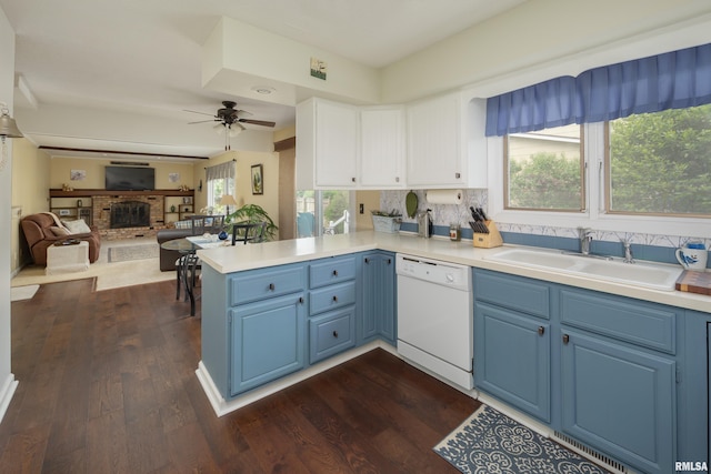 2828 Jersey Ridge Rd, Davenport, IA 52803 - kitchen with white dishwasher, a sink, blue cabinetry, a peninsula, and ceiling fan