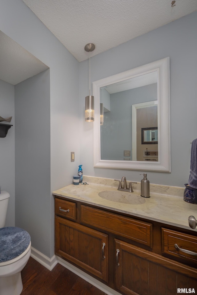 2828 Jersey Ridge Rd, Davenport, IA 52803 - half bathroom featuring toilet, wood finished floors, vanity, and baseboards