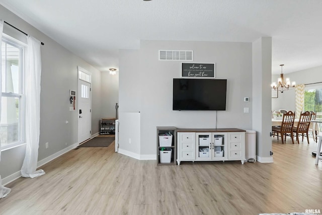 4625 W 11th St, Davenport, IA 52804 - living area featuring a chandelier, light wood finished floors, and baseboards