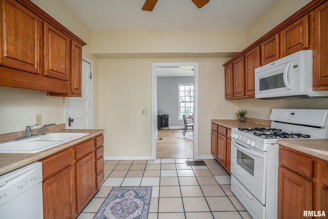534 Lincoln Ct, Davenport, IA 52804 - kitchen with white appliances, a sink, brown cabinets, light countertops, and a ceiling fan