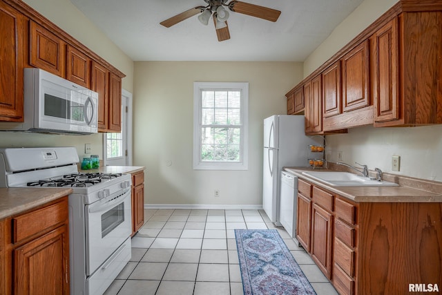 534 Lincoln Ct, Davenport, IA 52804 - kitchen with white appliances, a sink, a ceiling fan, brown cabinets, and light tile patterned flooring