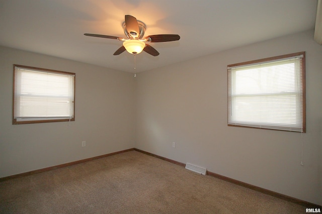 empty room with a ceiling fan, carpet floors, and baseboards