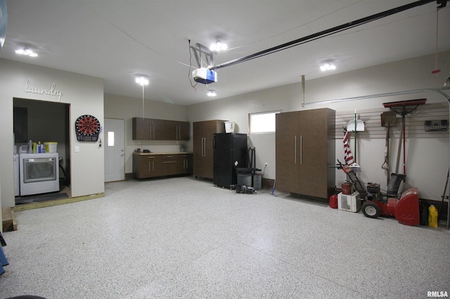 garage with washer / dryer, freestanding refrigerator, and a garage door opener
