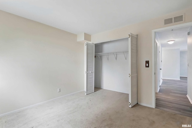 unfurnished bedroom with carpet flooring, a closet, and baseboards