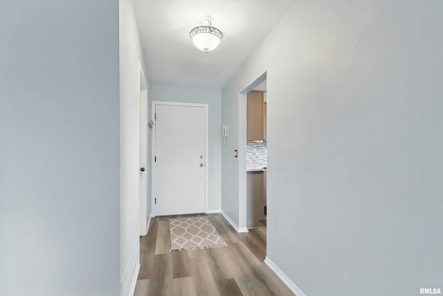 hallway with light wood-type flooring and baseboards