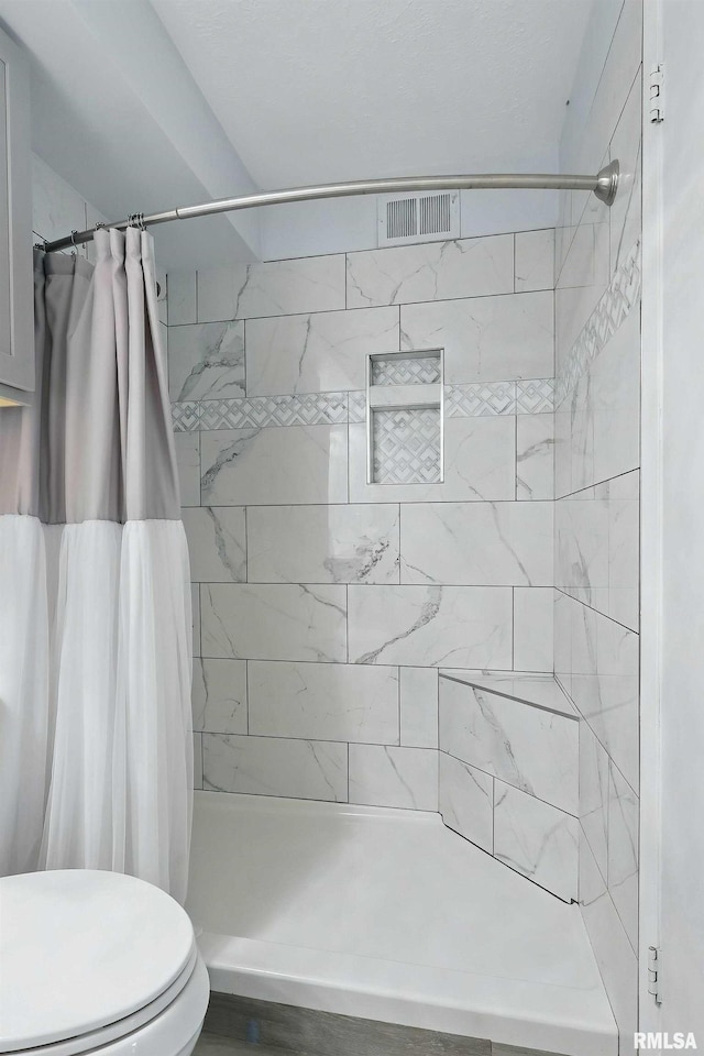 full bath with a stall shower and toilet