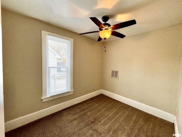 1207 Tremont Ave, Davenport, IA 52803 - spare room with dark carpet, ceiling fan, and baseboards
