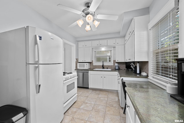 2544 E St, Davenport, IA 52803 - kitchen with white appliances, a sink, white cabinetry, and decorative backsplash