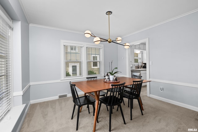 2544 E St, Davenport, IA 52803 - dining space with light carpet, ornamental molding, a chandelier, and baseboards