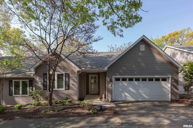 ranch-style house with an attached garage and asphalt driveway