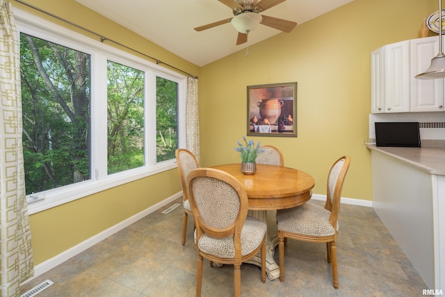 dining area featuring vaulted ceiling, a ceiling fan, and baseboards