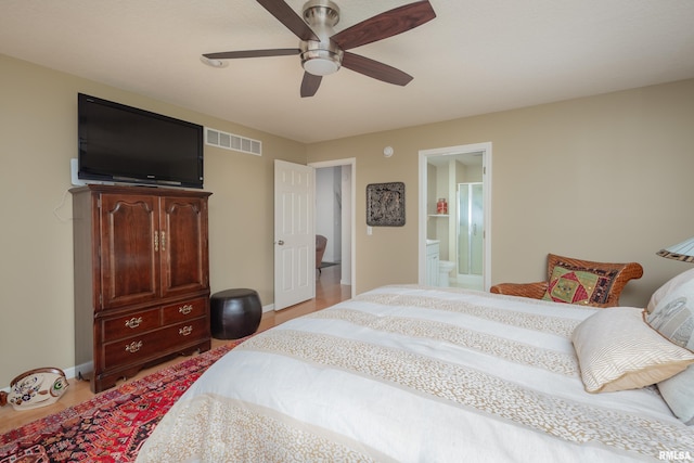 bedroom with light wood-style flooring, ceiling fan, baseboards, and ensuite bath