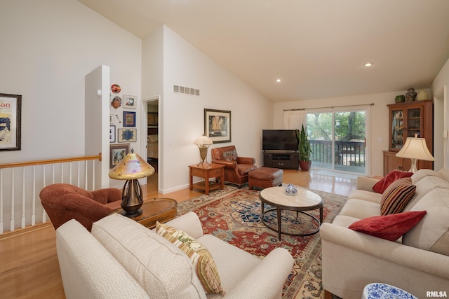 living area featuring light wood-type flooring, high vaulted ceiling, and recessed lighting