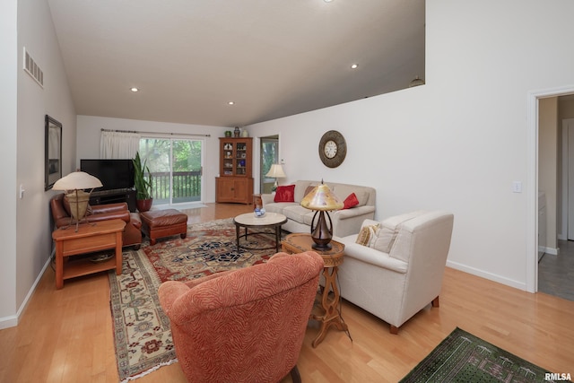 living room with light wood-style flooring, baseboards, recessed lighting, and lofted ceiling