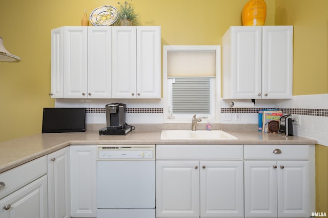 kitchen with white dishwasher, a sink, white cabinetry, and light countertops