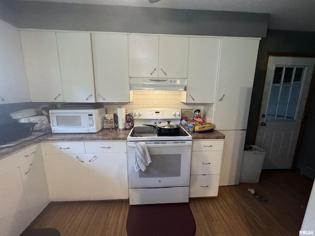 kitchen featuring white appliances, under cabinet range hood, dark wood-style floors, and white cabinets