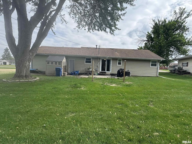 back of house featuring a patio, a lawn, a storage shed, and an outbuilding