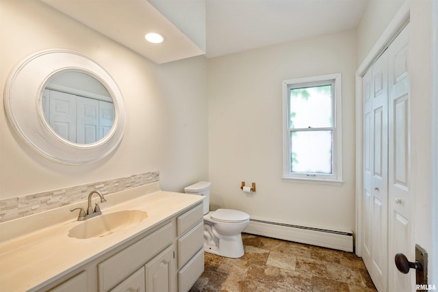 bathroom featuring baseboard heating, a closet, vanity, toilet, and recessed lighting