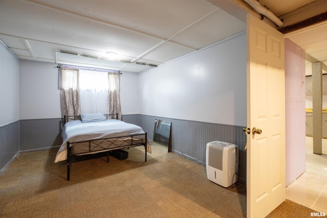 carpeted bedroom featuring wainscoting