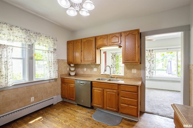 kitchen featuring stainless steel dishwasher, a sink, a baseboard radiator, radiator heating unit, and a chandelier