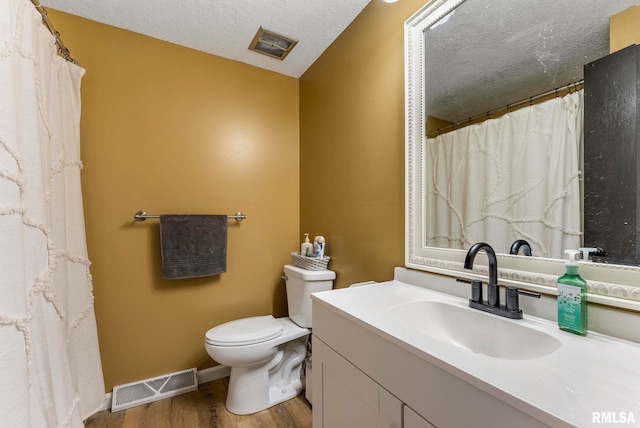 2115 W 31st St, Davenport, IA 52804 - full bath with wood finished floors, toilet, vanity, a textured ceiling, and baseboards