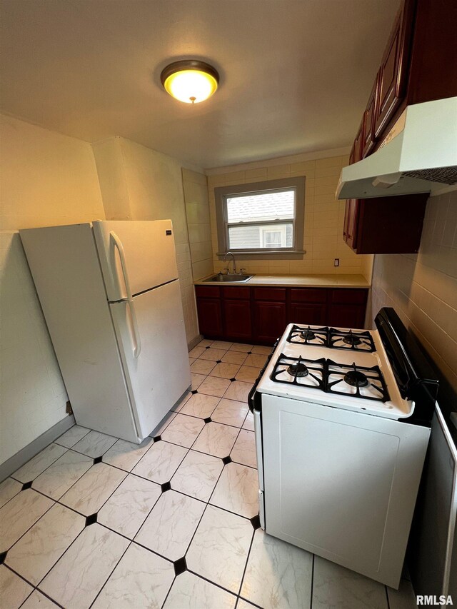 1701 2nd St, Moline, IL 61265 - kitchen featuring white appliances, under cabinet range hood, a sink, and light marble finish floors