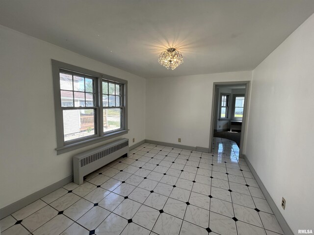 1701 2nd St, Moline, IL 61265 - spare room with radiator, a chandelier, and baseboards