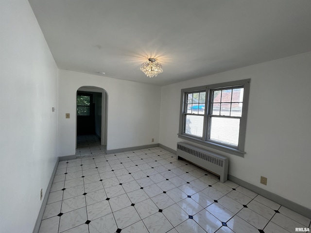 1701 2nd St, Moline, IL 61265 - unfurnished room with radiator, arched walkways, healthy amount of natural light, and a chandelier