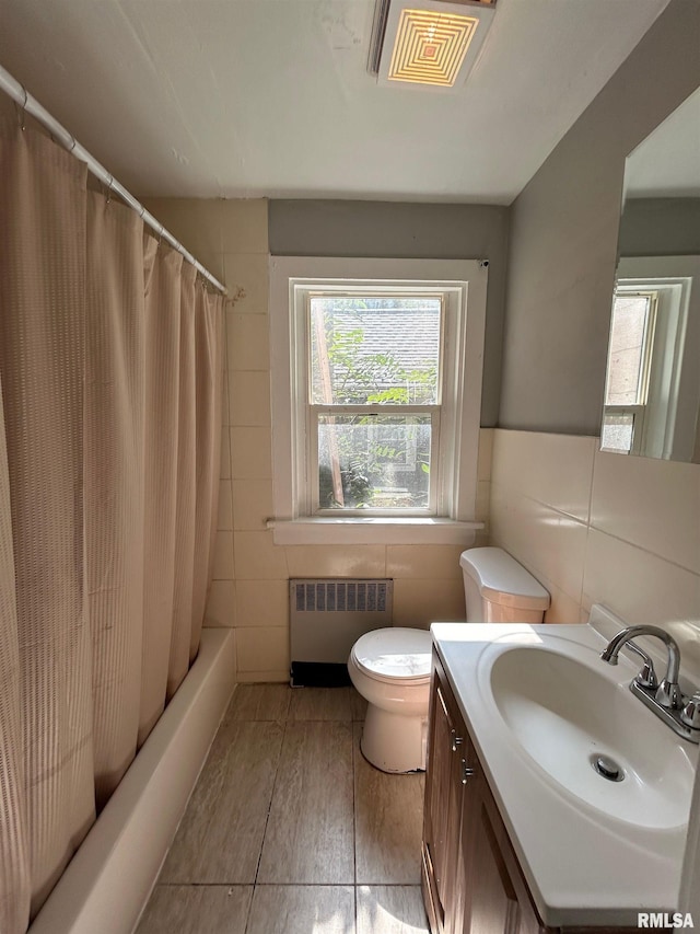 1701 2nd St, Moline, IL 61265 - bathroom featuring radiator, tile walls, healthy amount of natural light, toilet, and vanity