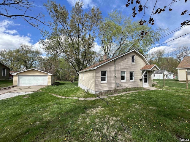 309 28th Ave, East Moline, IL 61244 - view of side of property featuring a detached garage, an outdoor structure, a chimney, and a lawn