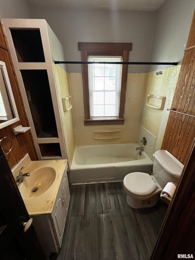 243 44th St, Moline, IL 61265 - bathroom with toilet, wood finished floors, washtub / shower combination, vanity, and tile walls