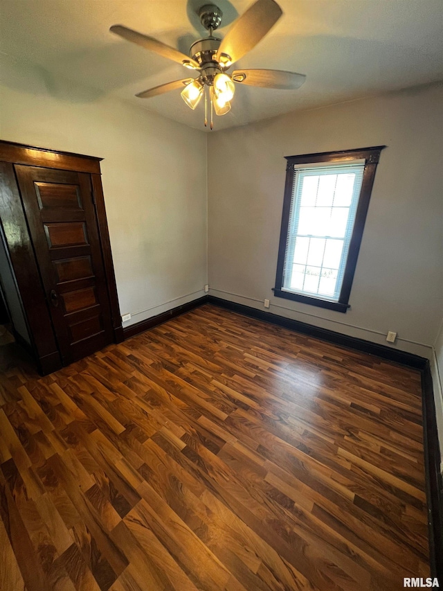 243 44th St, Moline, IL 61265 - spare room with dark wood-type flooring, a ceiling fan, and baseboards