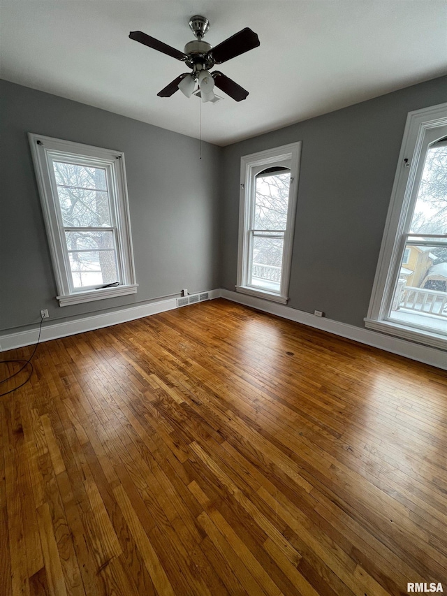 724 W 8th St, Davenport, IA 52804 - empty room with plenty of natural light, hardwood / wood-style flooring, a ceiling fan, and baseboards