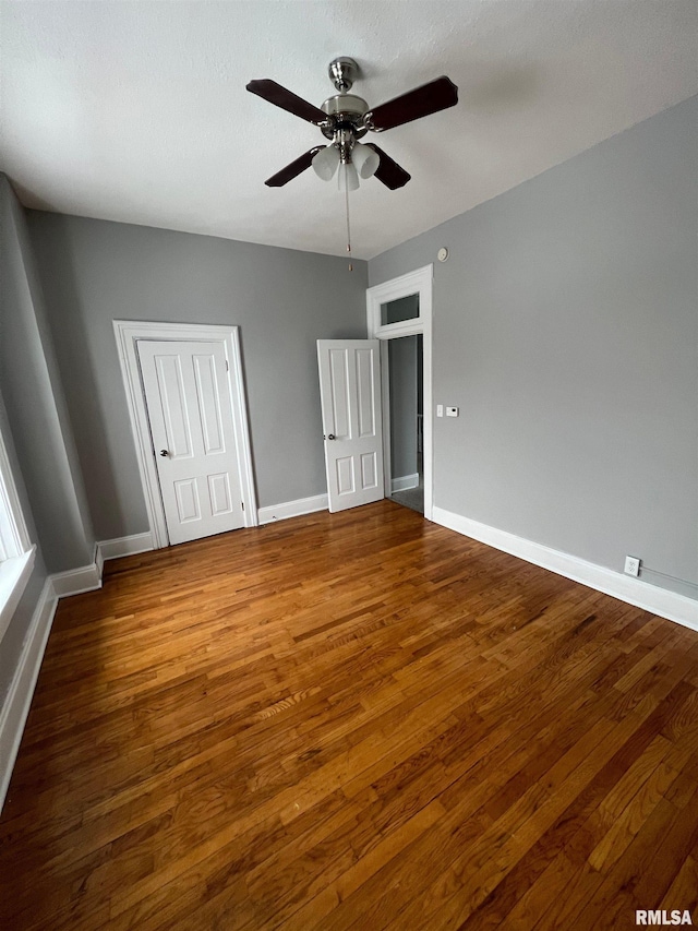 724 W 8th St, Davenport, IA 52804 - unfurnished bedroom featuring wood finished floors, baseboards, and a ceiling fan