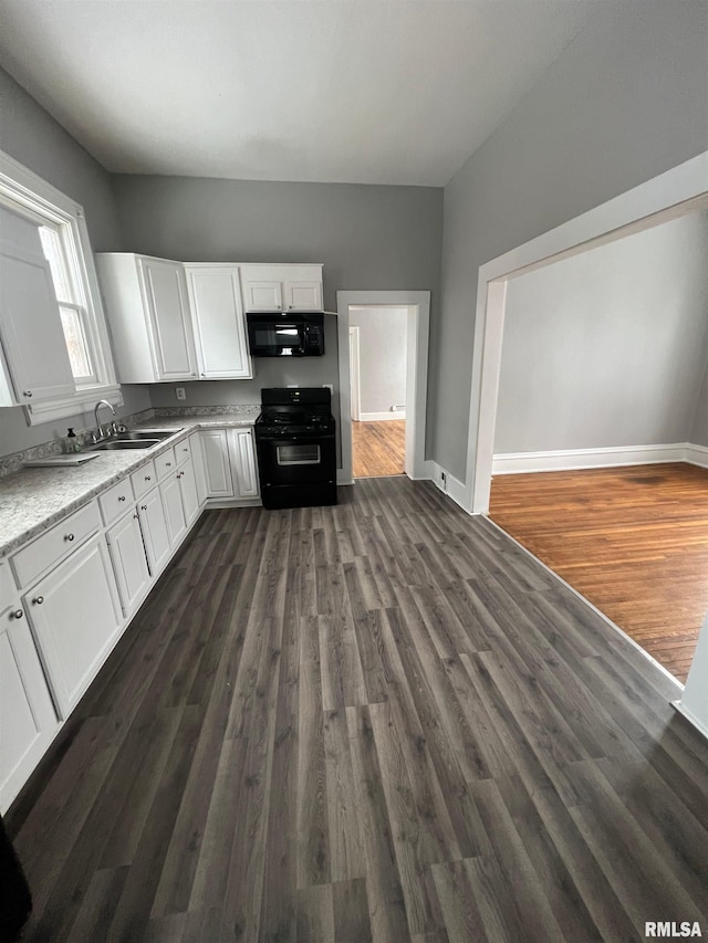 724 W 8th St, Davenport, IA 52804 - kitchen with black appliances, a sink, white cabinets, dark wood-type flooring, and baseboards