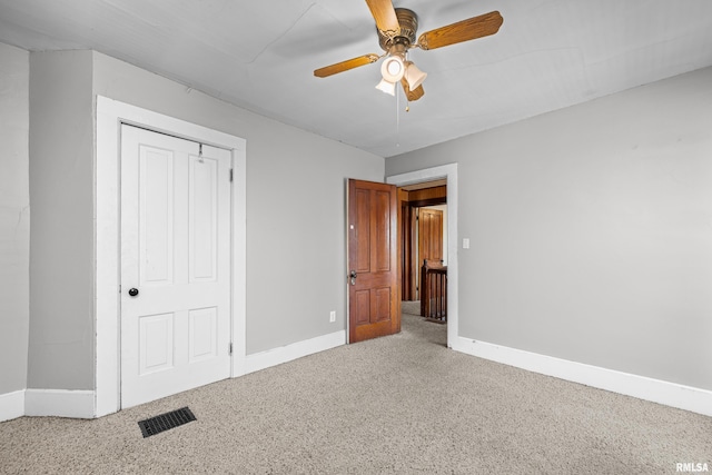 unfurnished bedroom featuring baseboards, ceiling fan, a closet, and carpet flooring