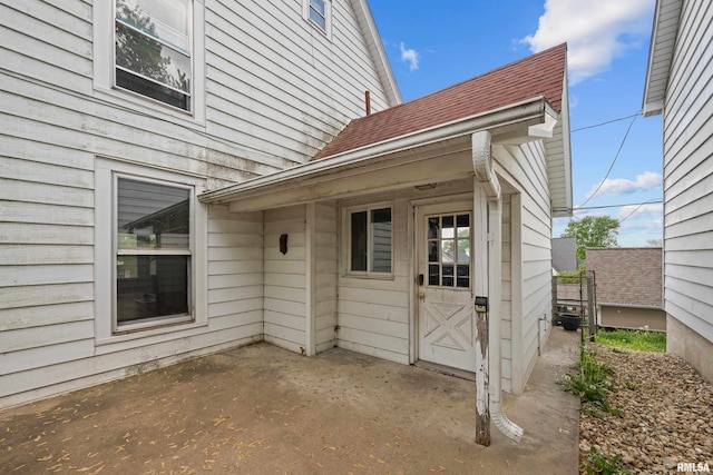 view of exterior entry with a patio area