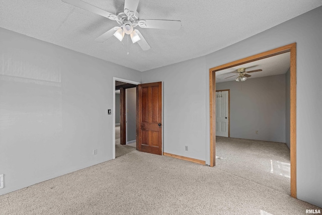 carpeted empty room featuring a ceiling fan and a textured ceiling