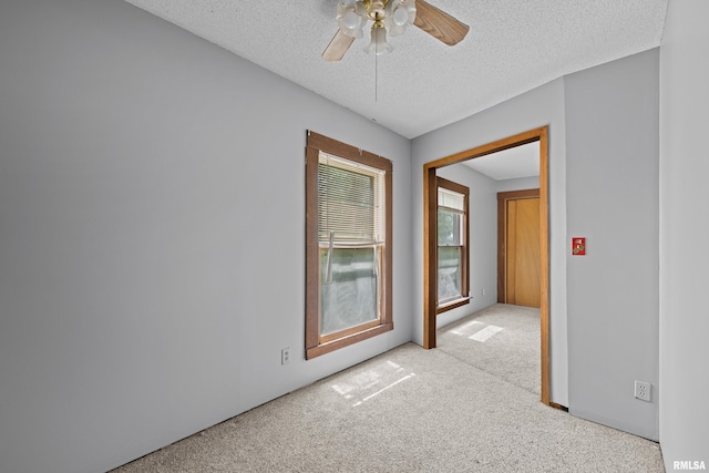 carpeted spare room with ceiling fan and a textured ceiling