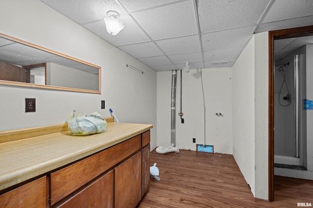 bathroom with a paneled ceiling and wood finished floors
