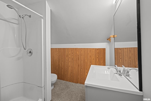bathroom with a stall shower, vanity, toilet, and vaulted ceiling