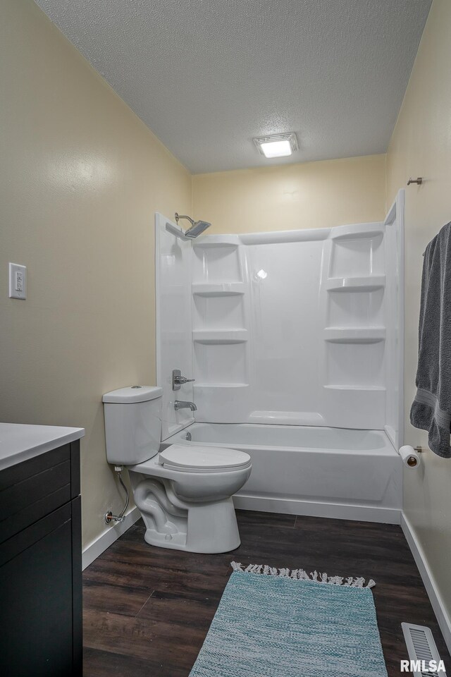 1729 Welshire Dr, Davenport, IA 52806 - bathroom with toilet, a textured ceiling, wood finished floors, bathtub / shower combination, and baseboards