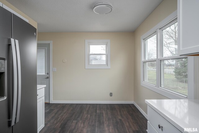 1729 Welshire Dr, Davenport, IA 52806 - unfurnished dining area with dark wood finished floors, baseboards, and healthy amount of natural light