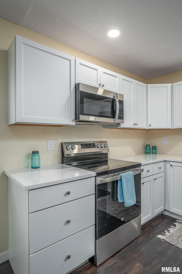 1729 Welshire Dr, Davenport, IA 52806 - kitchen with appliances with stainless steel finishes, dark wood-style flooring, white cabinetry, light countertops, and recessed lighting