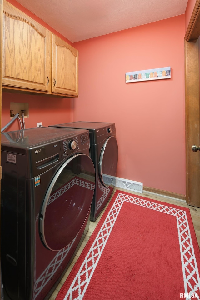 washroom with cabinet space and washing machine and dryer