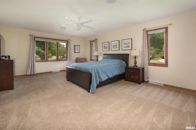 bedroom featuring light carpet, baseboards, and ceiling fan