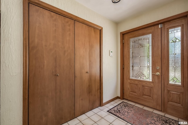 entryway featuring light tile patterned flooring and baseboards