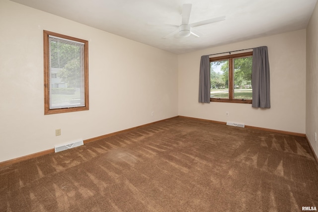 carpeted empty room featuring a ceiling fan and baseboards