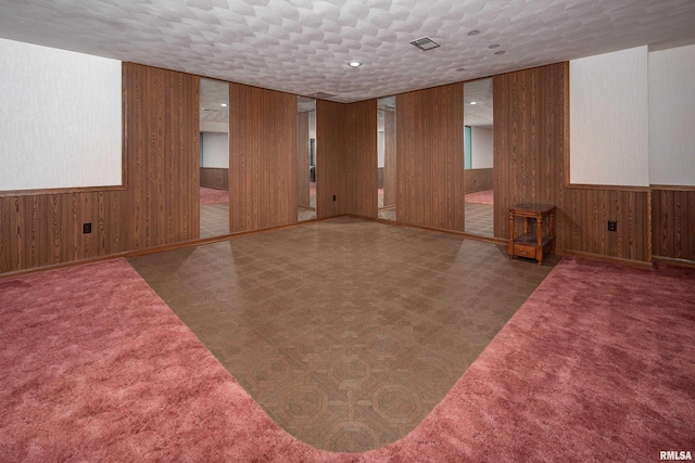 spare room featuring tile patterned floors and wood walls