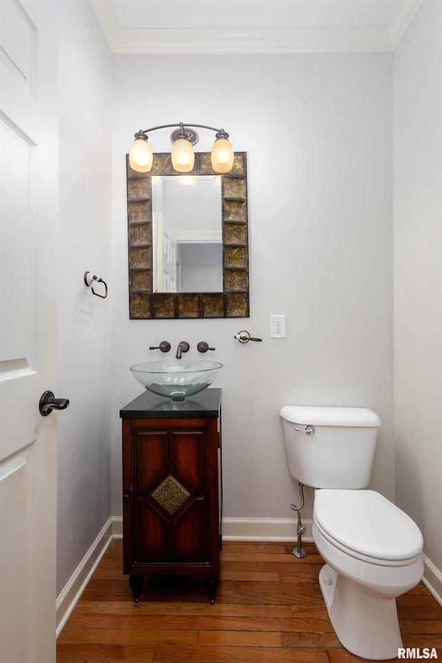 6800 Ridges Ct, Bettendorf, IA 52722 - half bath featuring crown molding, wood finished floors, baseboards, toilet, and vanity
